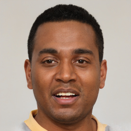 Joyful black young-adult male with short  black hair and brown eyes