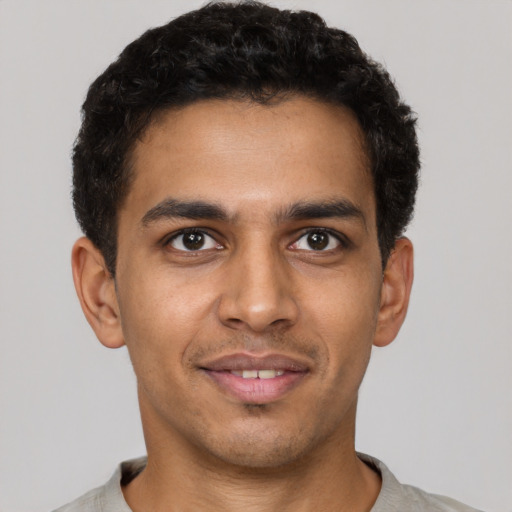 Joyful latino young-adult male with short  brown hair and brown eyes