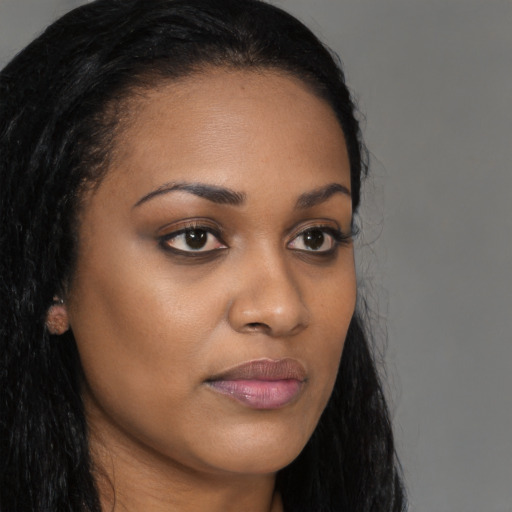 Joyful black young-adult female with long  brown hair and brown eyes