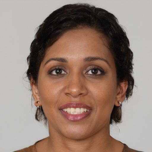 Joyful black adult female with medium  brown hair and brown eyes