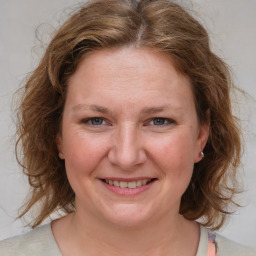 Joyful white young-adult female with medium  brown hair and blue eyes