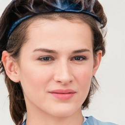 Joyful white young-adult female with medium  brown hair and blue eyes