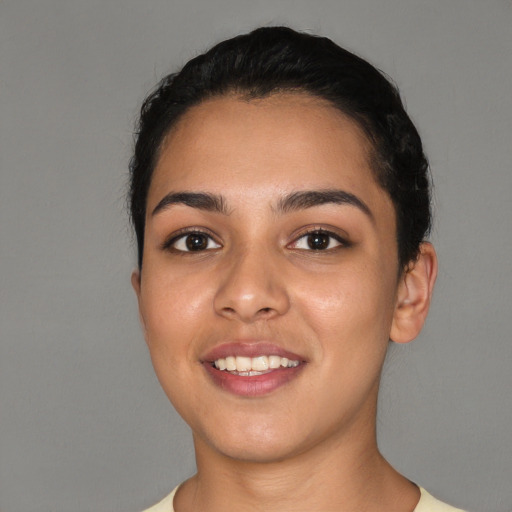 Joyful latino young-adult female with short  black hair and brown eyes