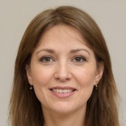 Joyful white adult female with long  brown hair and grey eyes