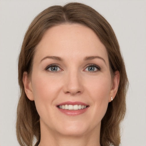 Joyful white young-adult female with long  brown hair and grey eyes