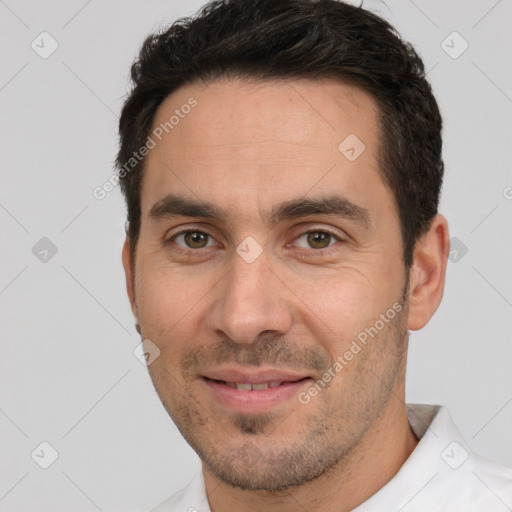 Joyful white adult male with short  black hair and brown eyes