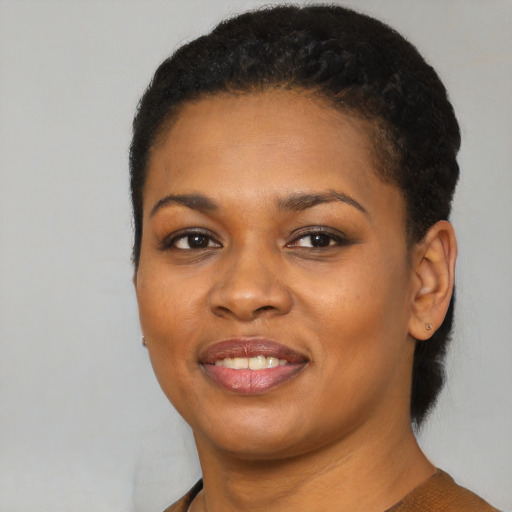 Joyful black young-adult female with short  black hair and brown eyes