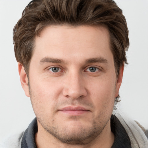 Joyful white young-adult male with short  brown hair and grey eyes