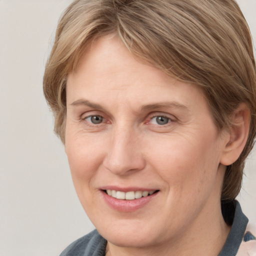 Joyful white adult female with medium  brown hair and grey eyes