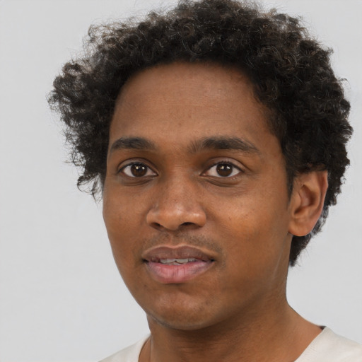 Joyful black young-adult male with short  brown hair and brown eyes