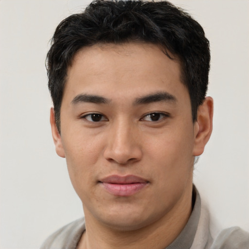 Joyful asian young-adult male with short  brown hair and brown eyes
