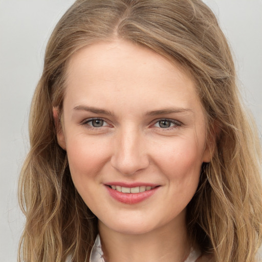 Joyful white young-adult female with long  brown hair and grey eyes