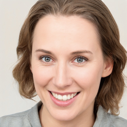 Joyful white young-adult female with medium  brown hair and blue eyes