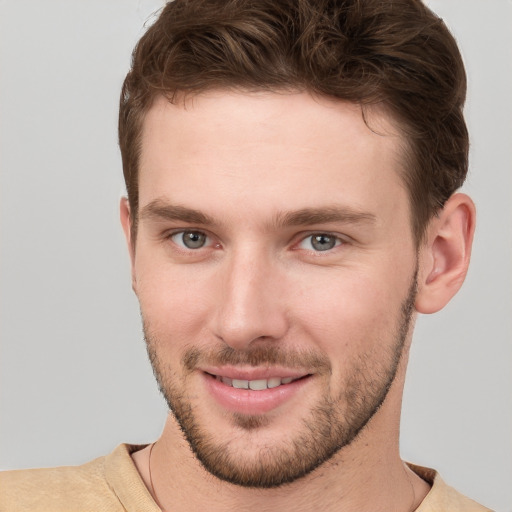 Joyful white young-adult male with short  brown hair and grey eyes