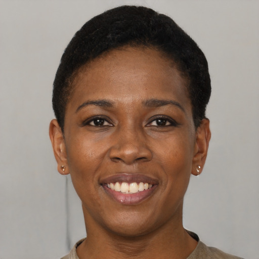 Joyful black young-adult female with short  black hair and brown eyes