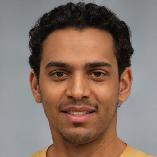 Joyful latino young-adult male with short  black hair and brown eyes