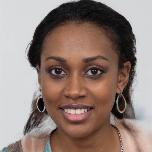 Joyful black young-adult female with long  black hair and brown eyes