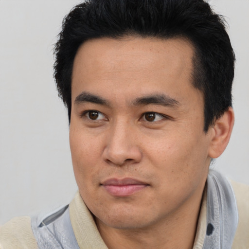 Joyful asian young-adult male with short  black hair and brown eyes