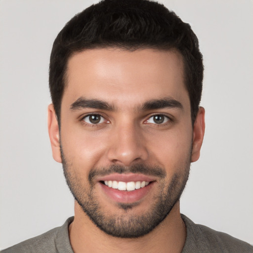 Joyful white young-adult male with short  black hair and brown eyes