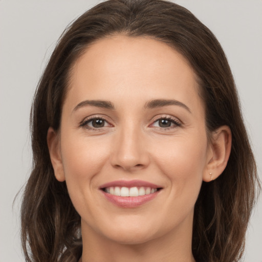 Joyful white young-adult female with long  brown hair and brown eyes