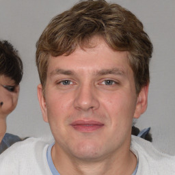 Joyful white adult male with short  brown hair and blue eyes