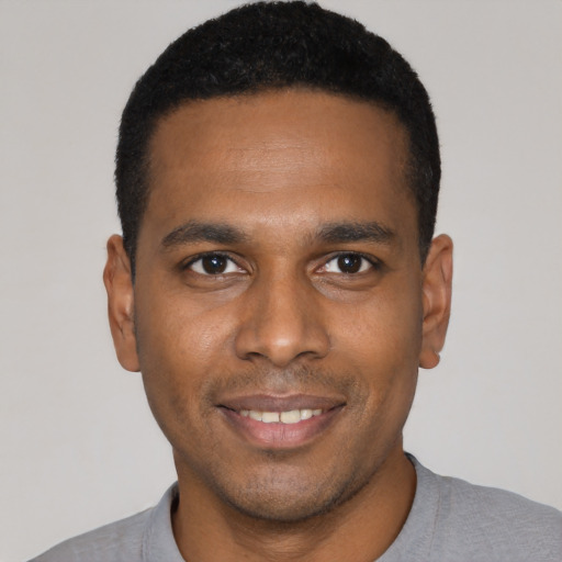 Joyful black young-adult male with short  black hair and brown eyes