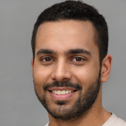 Joyful white young-adult male with short  black hair and brown eyes