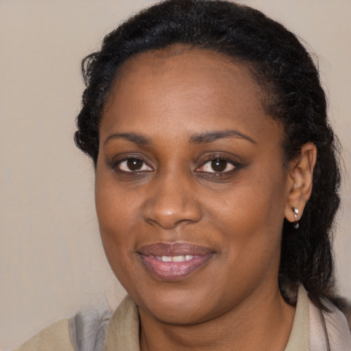 Joyful black young-adult female with long  brown hair and brown eyes