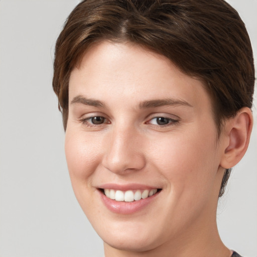 Joyful white young-adult female with short  brown hair and grey eyes