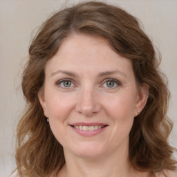 Joyful white adult female with medium  brown hair and grey eyes