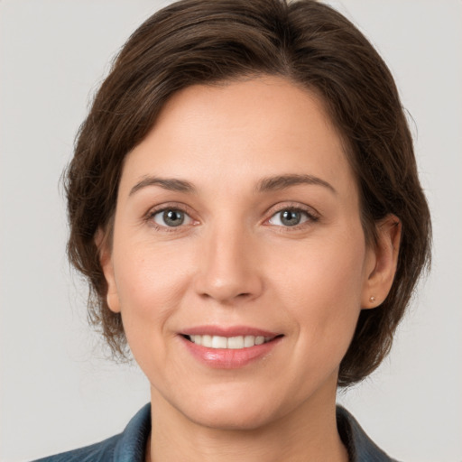 Joyful white young-adult female with medium  brown hair and grey eyes