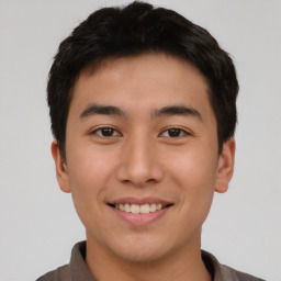 Joyful asian young-adult male with short  brown hair and brown eyes