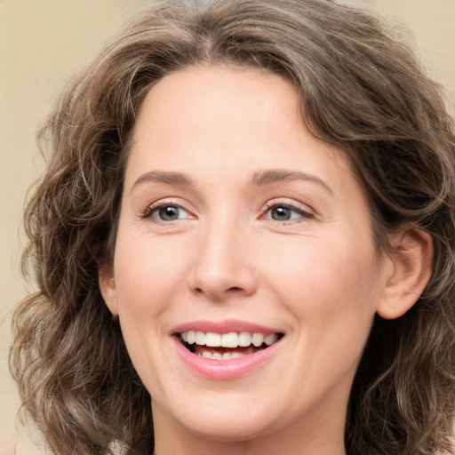 Joyful white young-adult female with medium  brown hair and green eyes