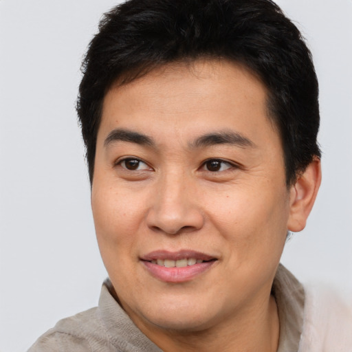 Joyful asian young-adult male with short  brown hair and brown eyes