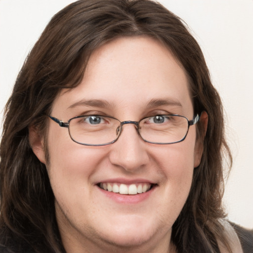 Joyful white adult female with long  brown hair and blue eyes