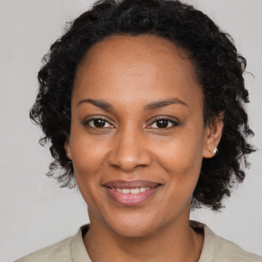 Joyful black young-adult female with medium  brown hair and brown eyes