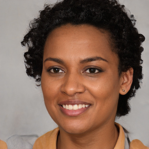 Joyful black young-adult female with long  brown hair and brown eyes