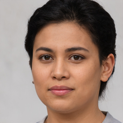 Joyful latino young-adult female with short  brown hair and brown eyes