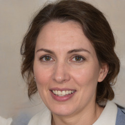 Joyful white adult female with medium  brown hair and green eyes