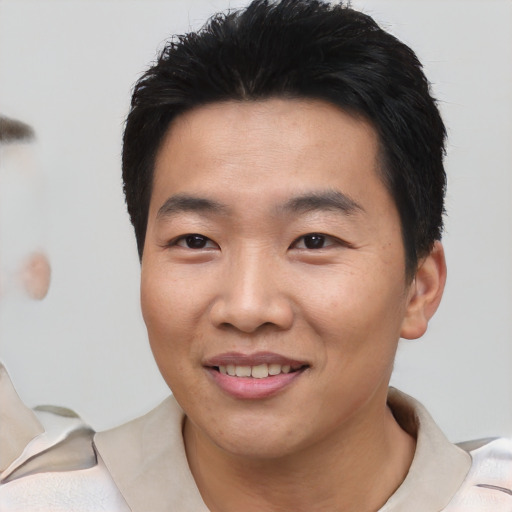 Joyful asian young-adult male with short  black hair and brown eyes
