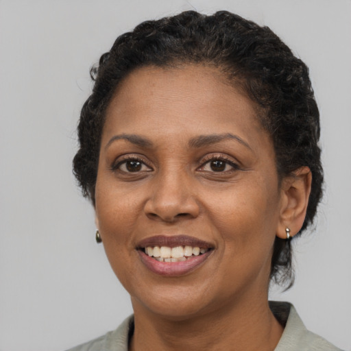 Joyful black adult female with short  brown hair and brown eyes