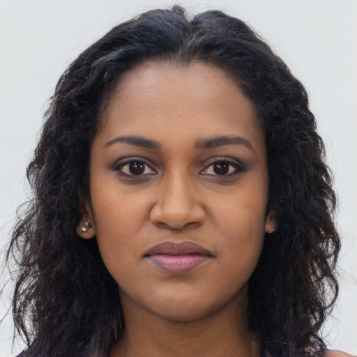 Joyful black young-adult female with long  black hair and brown eyes