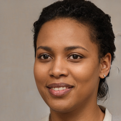 Joyful black young-adult female with medium  brown hair and brown eyes