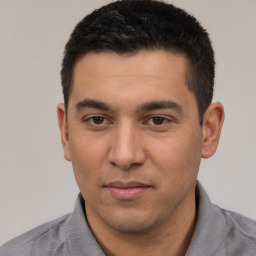 Joyful white young-adult male with short  black hair and brown eyes