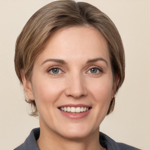 Joyful white adult female with medium  brown hair and grey eyes