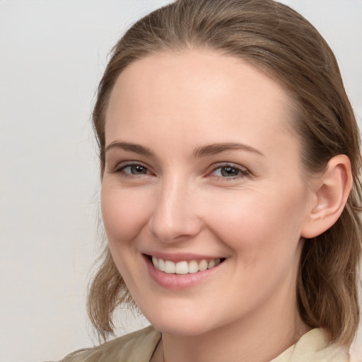 Joyful white young-adult female with medium  brown hair and grey eyes