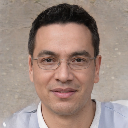 Joyful white adult male with short  black hair and brown eyes