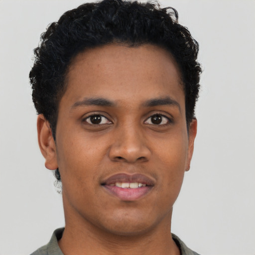 Joyful black young-adult male with short  black hair and brown eyes