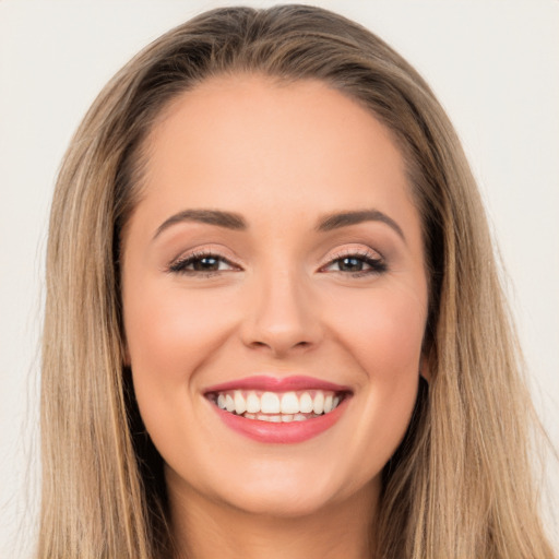 Joyful white young-adult female with long  brown hair and brown eyes