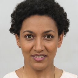 Joyful black young-adult female with short  black hair and brown eyes